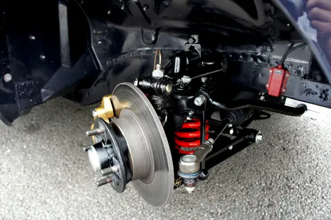 Front suspension corner viewed from below with wheel removed, arms, spring and brake disc visible