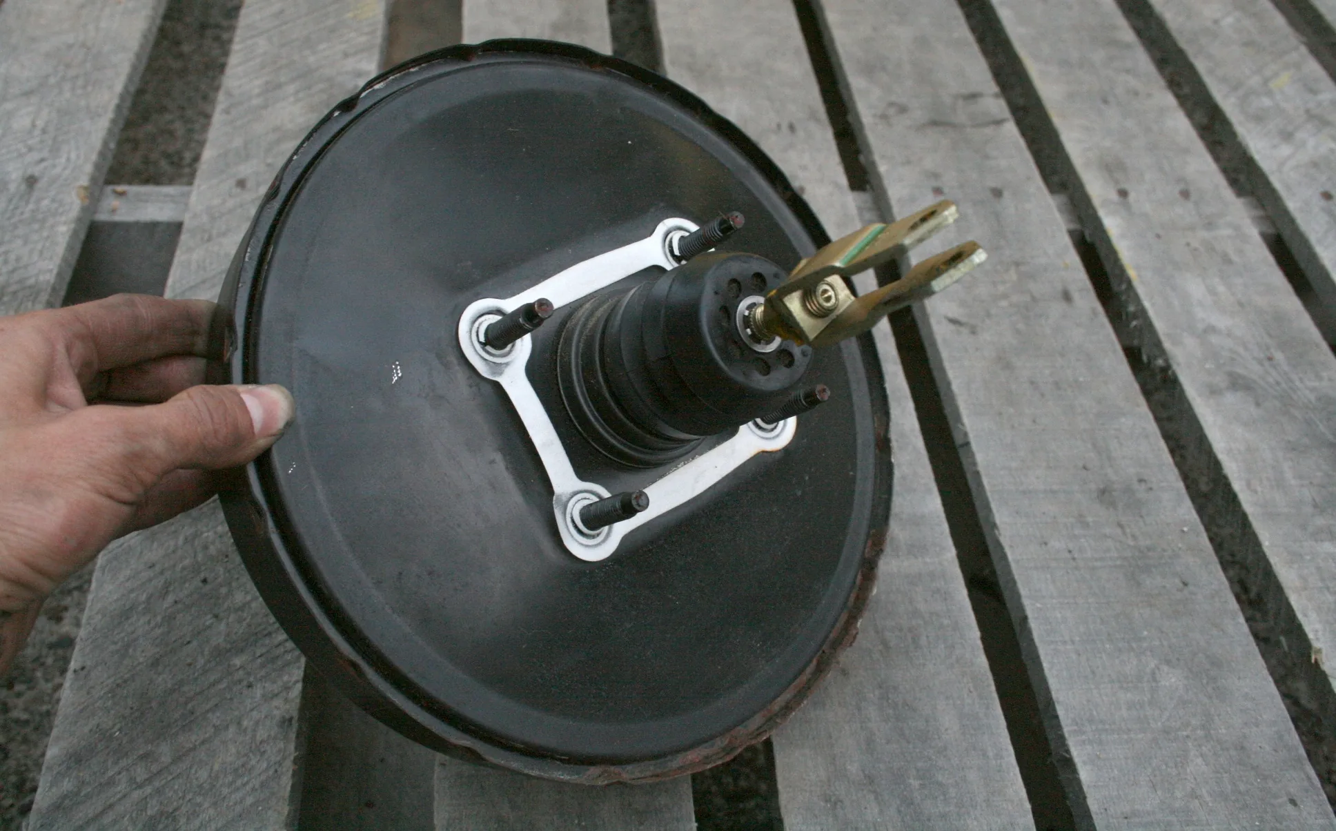 Removed round vacuum brake booster with mounting studs and a central pushrod