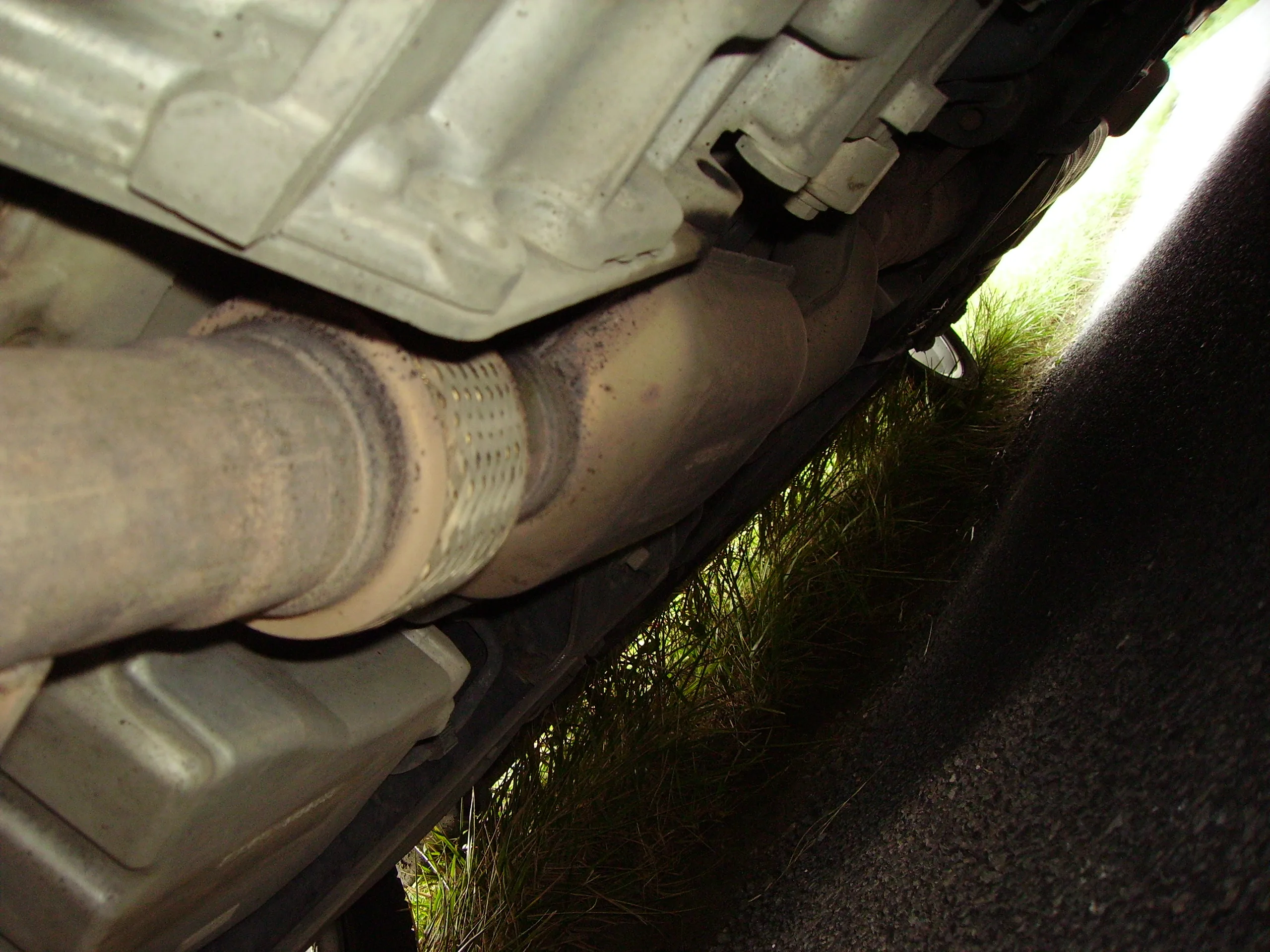 Converter housing in an installed exhaust system beneath a vehicle