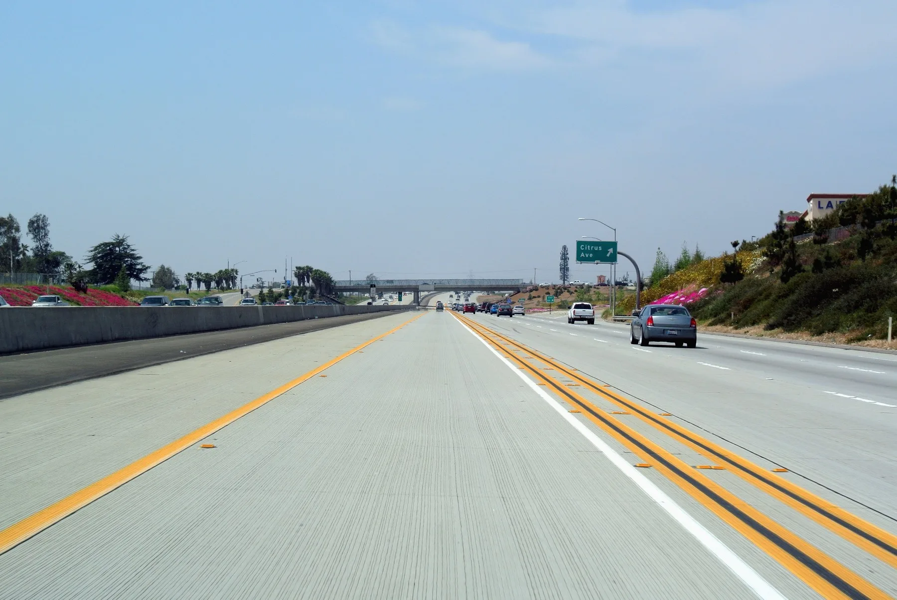Freeway carpool lane separated from other lanes by painted lines and a buffer