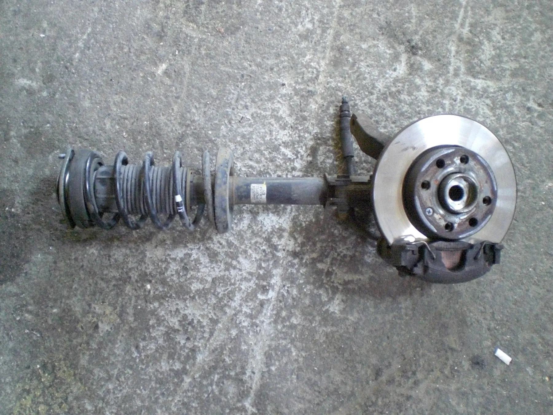 Removed strut assembly with coil spring, damper, knuckle, hub and brake disc