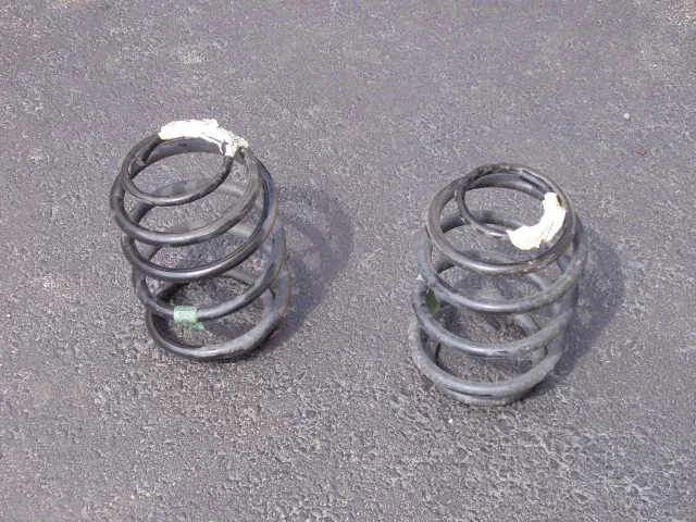 Two removed coil springs of different visible condition