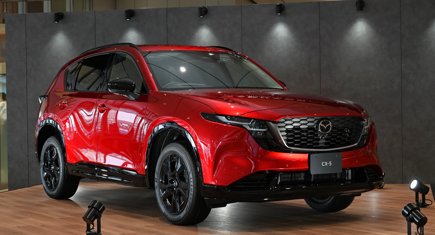 Front three-quarter of a third-generation Mazda CX-5 with two stacked LED daytime strips, a bright grille wing, and Mazda spelled across the nose