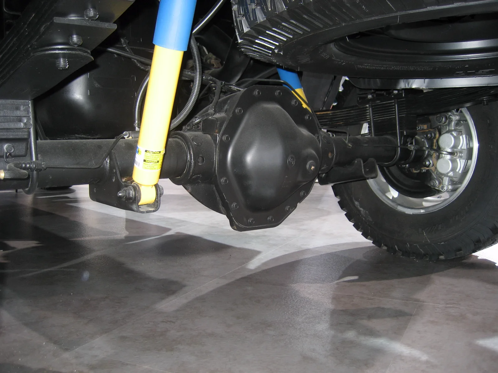 Ram 10.5-inch rear axle pumpkin and axle tubes, yellow shock, wheel at the right end