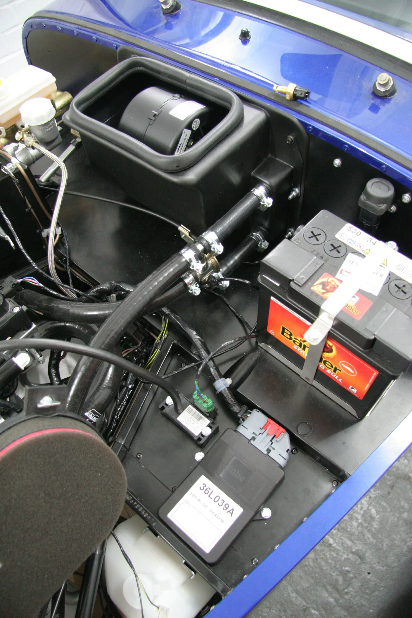 Engine bay with hoses running toward the cabin bulkhead