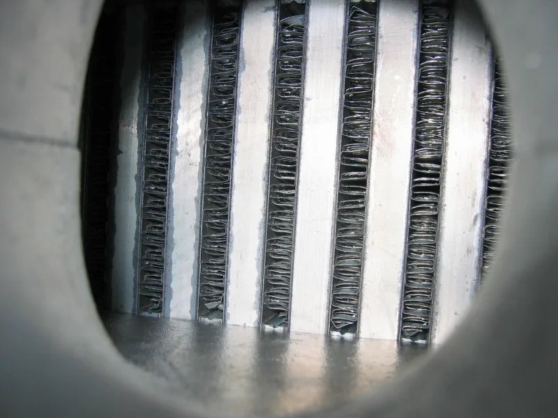 Close-up of the open face of an air-to-air intercooler, rows of passages and the fins between them