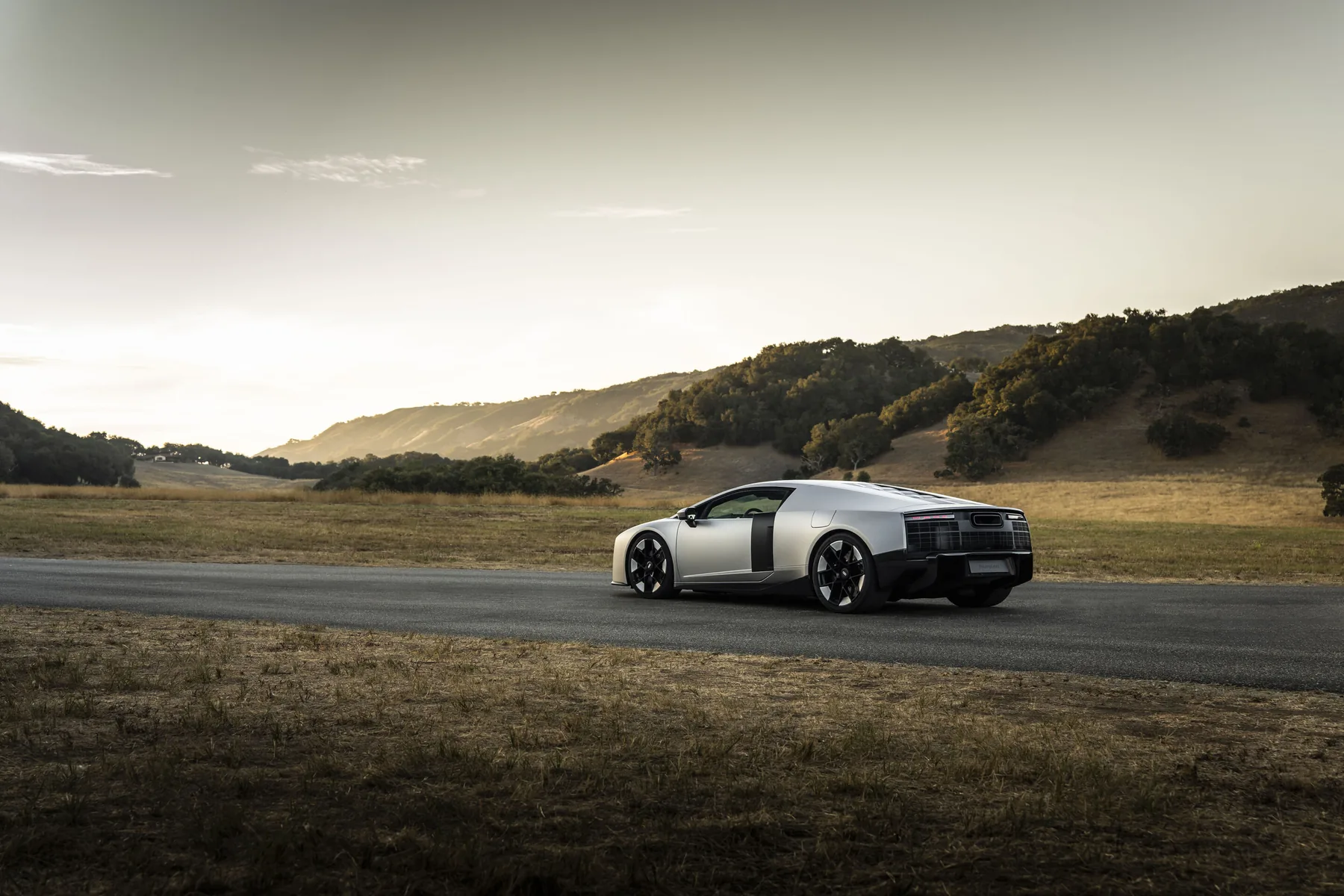 Gray Audi Nuvolari near-production prototype in side profile on a California road, with a large side intake and low roof