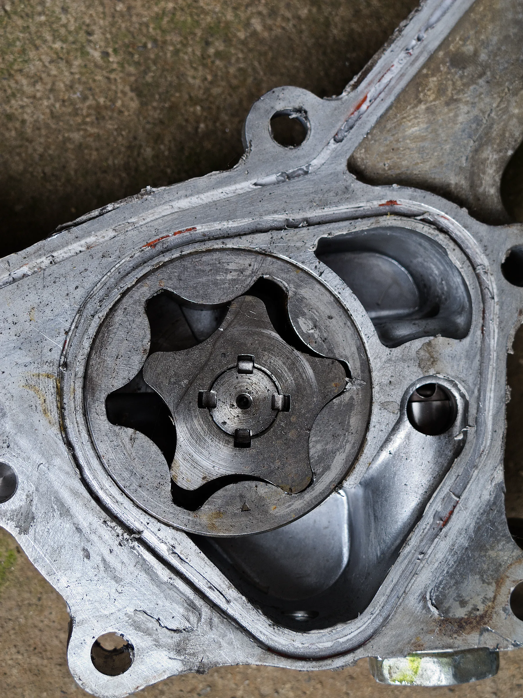 Oil pump from a Toyota 1HZ engine, a cast housing with a mounting flange and a drive gear on the shaft