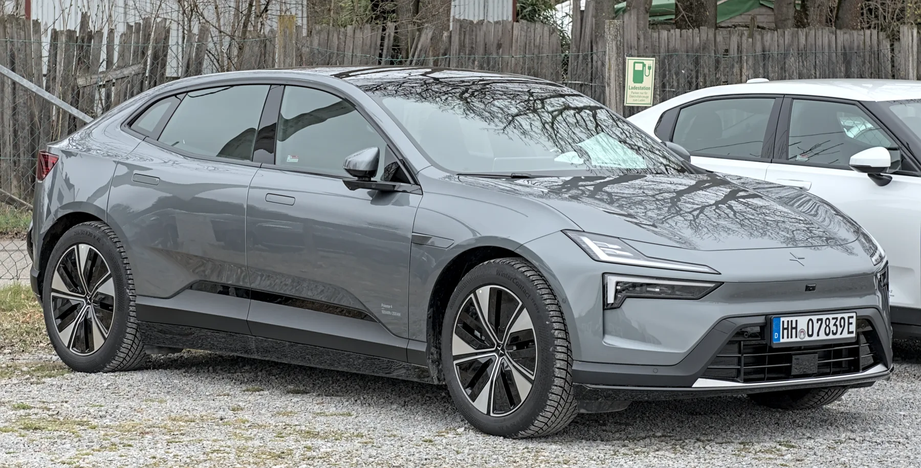 Rear three-quarter of a Polestar 4 in Stuttgart-Vaihingen, solid tailgate, full-width light bar, and a pod at the top of the hatch