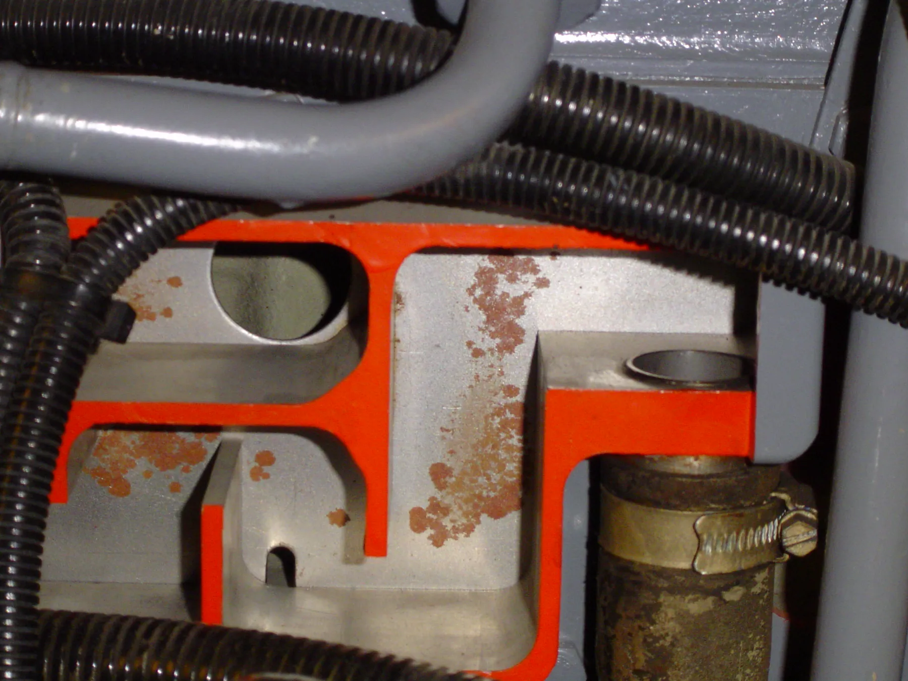 Cutaway crankcase breather showing internal passages and an outlet hose