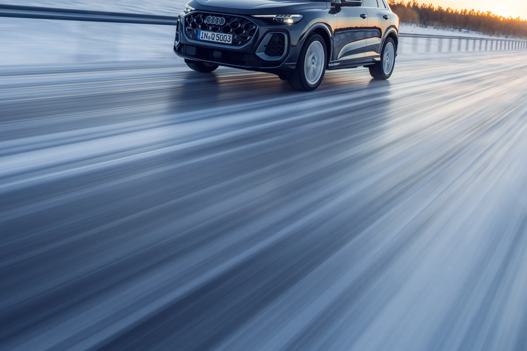 Third-generation Audi Q5 in Tambora grey, driving on a snowy road; global manufacturer press photograph