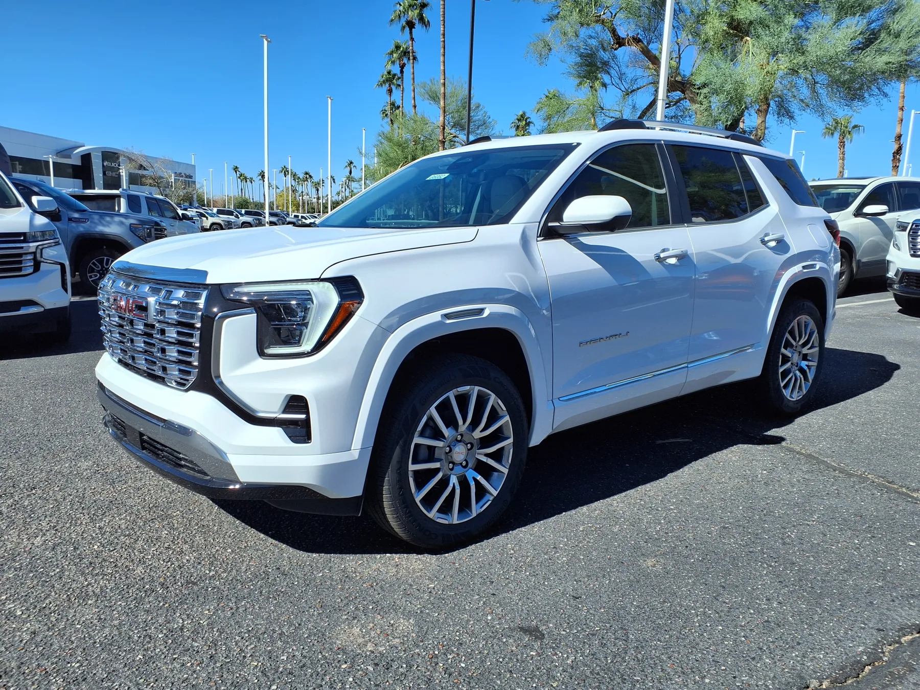 Front three-quarter of a 2026 GMC Terrain Denali with a bright chrome grille and chrome trim along the side glass